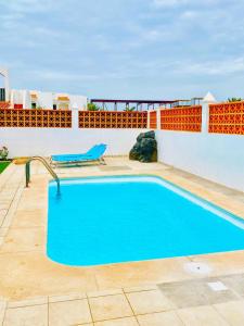 a swimming pool on the side of a house at Golden Wave Surf Villa in Corralejo