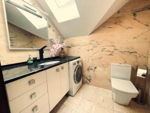 a bathroom with a sink and a washing machine at Marble Apartament in Zamość +40 photos