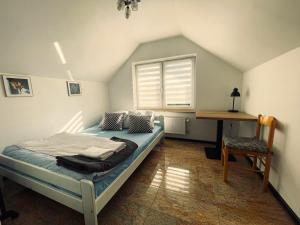 um quarto com uma cama, uma janela e uma secretária em Marble Apartament em Zamość