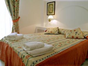 1 dormitorio con 1 cama con toallas en Ona Aldea del Mar, en Torrevieja
