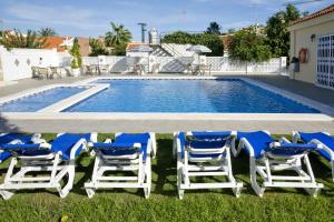 a group of blue and white chairs and a swimming pool at Ona Aldea del Mar in Torrevieja