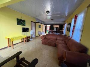a living room with a brown couch and a table at Casa Artavia in Tortuguero