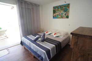um quarto com uma cama com um bicho de peluche em LES HAUTS DE LA BAIE em Bouillante