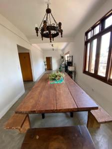 uma grande mesa de madeira num quarto com um lustre em Casa Praiana no Guarujá