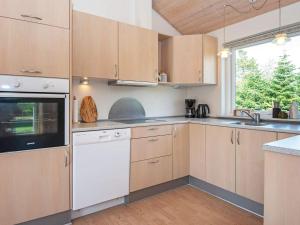 eine Küche mit weißen Geräten und einem Fenster in der Unterkunft 6 person holiday home in Skjern in Halby