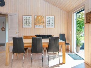 a dining room with a wooden table and chairs at 6 person holiday home in Skjern in Halby