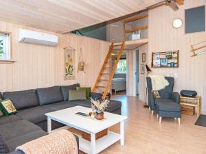 ein Wohnzimmer mit einem Sofa, einem Tisch und einer Leiter in der Unterkunft 6 person holiday home in Skjern in Halby