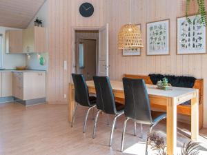 Halbyにある6 person holiday home in Skjernのダイニングルーム(テーブル、黒い椅子付)