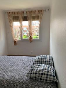 um quarto com uma cama com uma almofada e uma janela em Superbe T3 spacieux, lumineux et sans vis-à-vis em Vigneux-sur-Seine