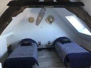 2 Betten in einem Dachzimmer mit 2 Fenstern in der Unterkunft 3 rue Barthélémy in Cherbourg en Cotentin
