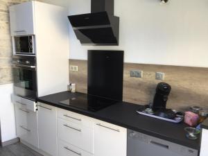 a kitchen with white cabinets and a black counter top at 3 rue Barthélémy in Cherbourg en Cotentin