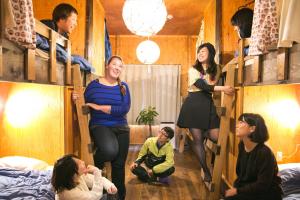 a group of people in a room with bunk beds at Guest House Waya in Sapporo