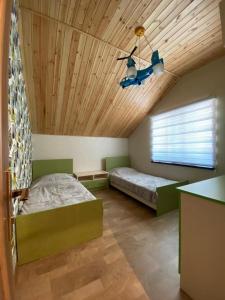 a bedroom with two beds and a wooden ceiling at Shale Qusar in Qusar