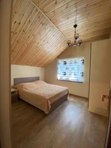 1 dormitorio con cama y techo de madera en Shale Qusar, en Qusar