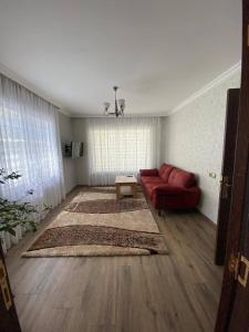 sala de estar con sofá rojo y alfombra en Shale Qusar, en Qusar