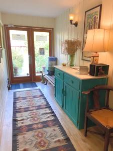uma cozinha com um armário verde e um tapete em Wisteria Guest House em Ganges