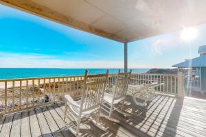 a deck with two chairs and the ocean at Sandstone in St. George Island