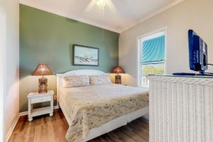a bedroom with a bed and a flat screen tv at Sandstone in St. George Island