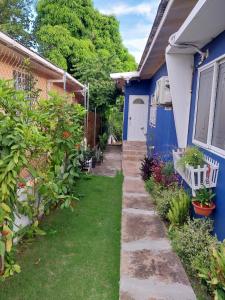 a garden outside a blue house with a yard at GranAnn's Place in Kingston