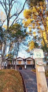 a house with a for sale sign in front of it at Terrace Chalés in Monte Verde