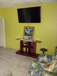sala de estar con TV de pantalla plana en una pared amarilla en GranAnn's Place en Kingston