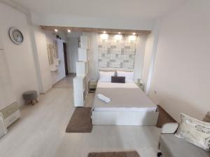 a white room with two beds and a couch at Fundeni - Garsoniere - langa spital in Bucharest