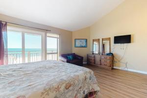 um quarto com uma cama, uma televisão e uma varanda em Ocean Mile F-1 em St. George Island