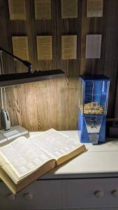 un libro abierto sentado en la parte superior de un mostrador con un jarrón en The Andiron Seaside Inn & Cabins, en Little River