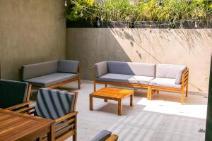 a patio with two couches and a table and chairs at Lumina at Noma Condesa Mexico City in Mexico City