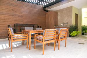 - une table et des chaises en bois sur la terrasse dans l'établissement Lumina at Noma Condesa Mexico City, à Mexico