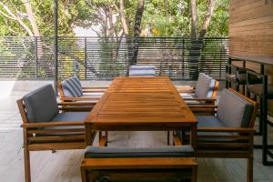 Une table et des chaises en bois sont disponibles sur la terrasse. dans l'établissement Lumina at Noma Condesa Mexico City, à Mexico