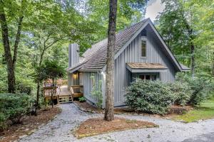 un cottage dans les bois avec un chemin menant à celui-ci dans l'établissement Laurel Grove, à Cashiers