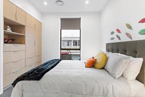 1 dormitorio con 1 cama con sábanas y almohadas blancas en Academy Apartments en Masterton