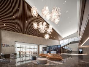 a lobby with chairs and chandeliers in a building at Holiday Inn Express Tengchong Hot-Spring, an IHG Hotel in Tengchong