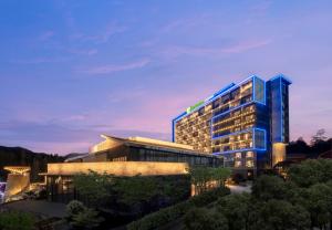 a large building with a blue lit up at Holiday Inn Express Tengchong Hot-Spring, an IHG Hotel in Tengchong