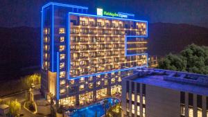 un hotel con luces azules en la parte superior de un edificio en Holiday Inn Express Tengchong Hot-Spring, an IHG Hotel, en Tengchóng