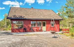 un cobertizo rojo con una silla y un columpio en Lovely Home In Hornnes With Kitchen, en Hornnes