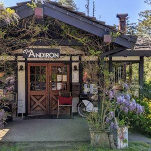 a shop with a door and a red chair outside at The Andiron Seaside Inn & Cabins in Little River