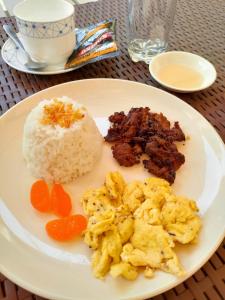 a white plate of food with rice and meat at NINIE'S PLACE in Puerto Princesa City