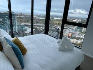 a large bed with two stuffed animals sitting on top of it at Lux 3 Bedroom 2 Bathroom Apt Southbank in Melbourne