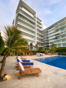 una piscina con tumbonas y un gran edificio en Apartamento en Cartagena con vista al mar, en Cartagena de Indias