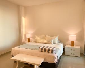 a bedroom with a bed with two lamps and a table at Vista al mar en Cartagena , Apartamento en Morros in Cartagena de Indias
