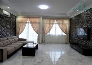 a living room with a couch and a flat screen tv at 99 Kelawei in George Town