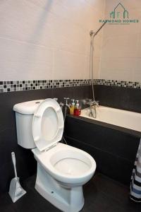 a bathroom with a white toilet and a bath tub at 99 Kelawei in George Town