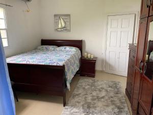 a bedroom with a bed and a door with a boat on the wall at Sky Blue Residence in Lower Princeʼs Quarter