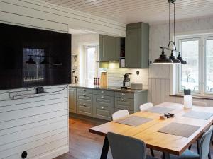 a kitchen with a wooden table and a dining room at Holiday home Grebbestad IX in Grebbestad