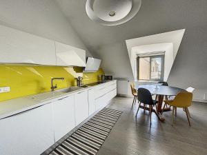 uma cozinha com uma mesa e uma parede amarela em Appartement Granville, 3 pièces, 4 personnes - FR-1-361-377 em Granville