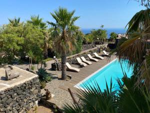 un complejo con una piscina con tumbonas en La Kuddia, en Pantelleria