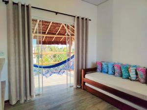 a bedroom with a bed and a large window at Sirena Village in São Miguel do Gostoso