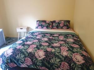 a bedroom with a bed with a floral bedspread at Vacation Getaway in Rowville